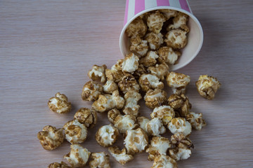 Sweet popcorn on the table. Popcorn in the pink bucket. Snack for the movies. Cinema set. Unhealthy food.