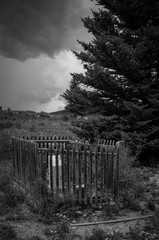 Old Grave With Wood Fence And Approching Storm