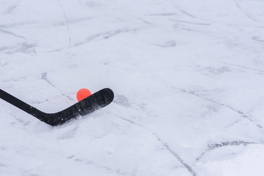close-up of a hockey stick with an orange ball