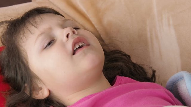 Sick child. The little girl is coughing.