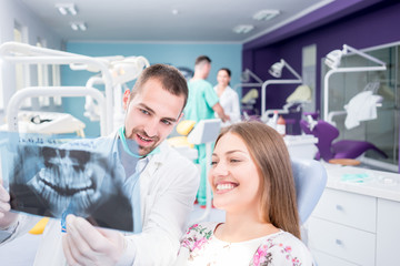 Doctor talking with patient and showing a radiograph in stomatology clinic. Dentist concept.