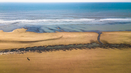 Drone view of the ocean and a beach in low tide 