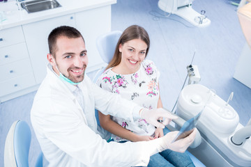 Doctor talking with patient and showing a radiograph in stomatology clinic. Dentist concept.