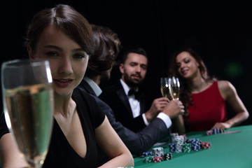 portrait of smiling woman with drink playing poker