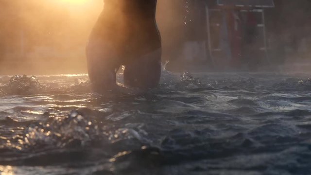 Geothermal spa. Woman relaxing in hot spring pool outdoors. Girl enjoying bathing in a blue water lagoon tourist attraction at sunset. Slow motion