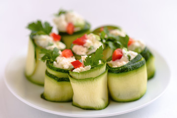 Rolls of zucchini stuffed with cheese and chives and red paprika.