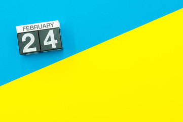 February 24th. Day 24 of february month, calendar on blue and yellow background flat lay, top view. Winter time. Empty space for text