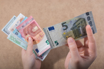 Hand holding American dollar  isolated on wooden background