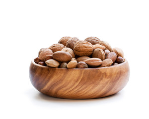 Various  nuts in wooden bowl isolated on white