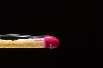 Match with water on top in the left corner of the frame on a black background
