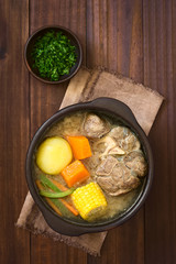 Traditional Chilean Cazuela de Vacuno or Cazuela de Carne beef soup with potato, corn, pumpkin, carrot, bell pepper, onion, rice, photographed overhead with natural light (Selective Focus on the soup)