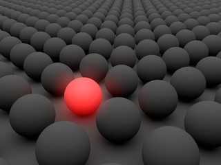 Red sphere between other black spheres; standing out, leader or success concept