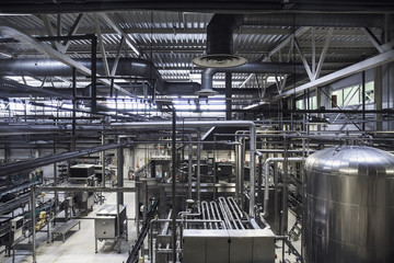 Modern brewery plant. Huge tanks or vat for beer  fermentation, industrial background with many steel pipes