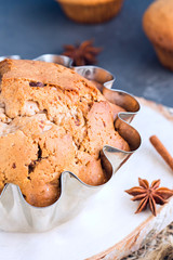 Big muffin in steel mold with cinnamon and star anise close-up