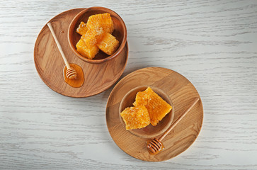 Bowls with fresh honeycombs on wooden table