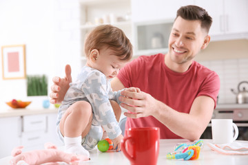 Father playing with his little son in kitchen