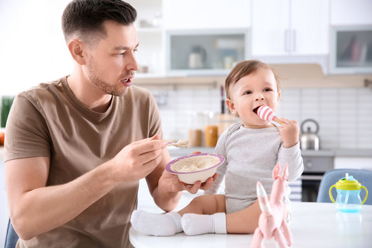 Father feeding his little son in kitchen
