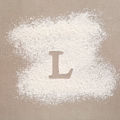 Silhouette of letter L on scattered flour