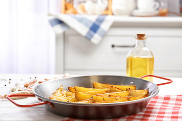 Dish with delicious oven baked potatoes on table