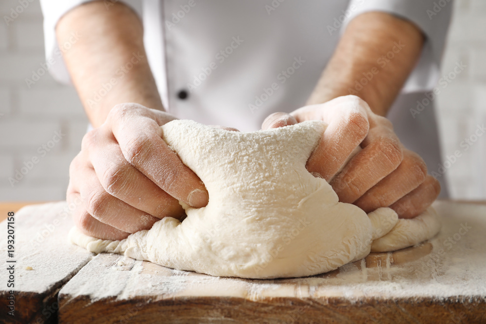 Sticker Man kneading dough on wooden board sprinkled with flour