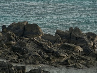 black lava rocks on the shore
