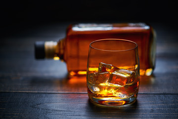 whiskey with ice  cube on a wooden table