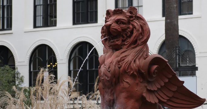 A daytime establishing shot of a lion water fountain in a southern American city.  	