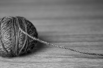 Tangle of knitting threads on the table and space for text, black and white photo