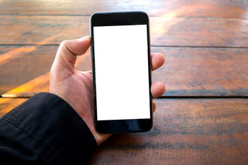 Male hand holding smart phone on blur wooden background.