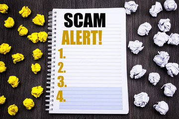 Conceptual hand writing text caption showing Scam Alert. Business concept for Fraud Warning Written on notepad note notebook book wooden background with sticky folded yellow and white
