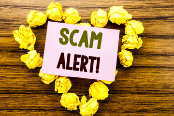Fototapeta premium Word, writing Scam Alert. Business concept for Fraud Warning written on sticky note paper on the wooden background.