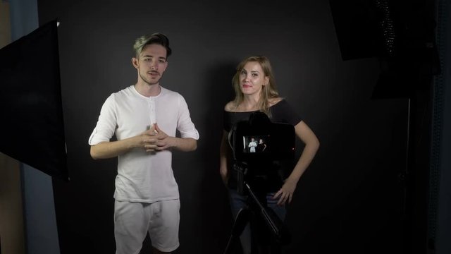 Young attractive teenagers couple in a professional studio shooting videos for their online vlogs