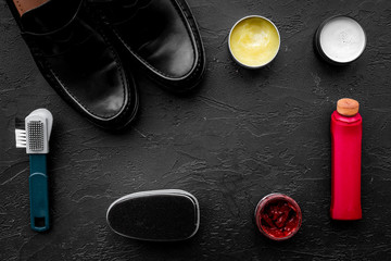 Shine shoes. Shoe care with polish, brushes, wax, sponge. Black background top view copy space
