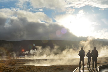 people in Yellowstone park near geyzer fog