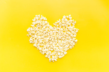 Popcorn mockup on yellow background top view copy space. Heart shape