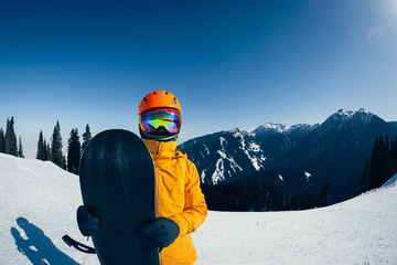 Fototapeta na wymiar one snowboarder with snowboard in winter mountains