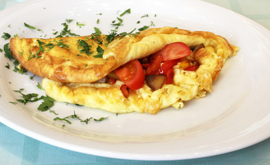appetizing omelette with tomatoes and greens