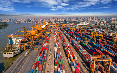 Obraz premium Logistics and transportation of Container Cargo ship and Cargo plane with working crane bridge in shipyard at sunrise, logistic import export and transport industry background