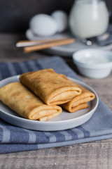 Russian Puncake Crepes stuffed with mushrooms and mozzarella on wooden table background.