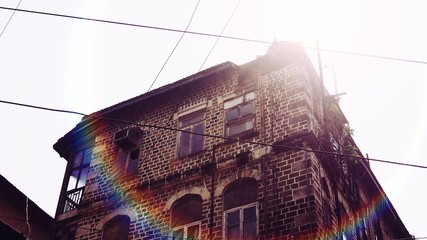 Old wrecked brick building with strong sunlight in the background.