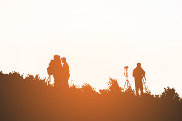 silhouette of people on top mountain after sunset. subject is blurred.