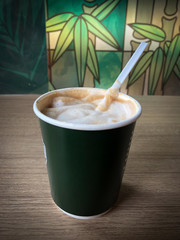 A cup of hot latte art  coffee on wooden table in coffee shop