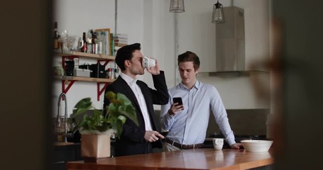 Young male couple kissing goodbye in the morning