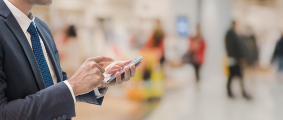 Businessman using smart phone in shopping mall space background and copy space.Concept of people shopping online technology.
