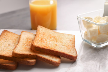 Marble board with tasty toasted bread and butter, closeup