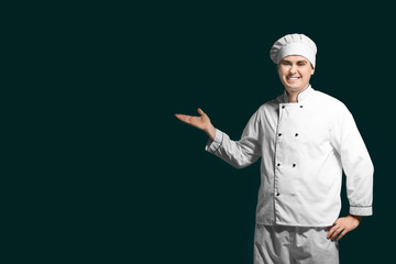 Male chef in uniform on dark background