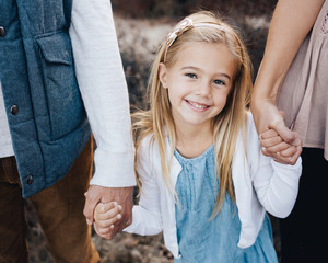Close up of a little girl holding mom and dads hands