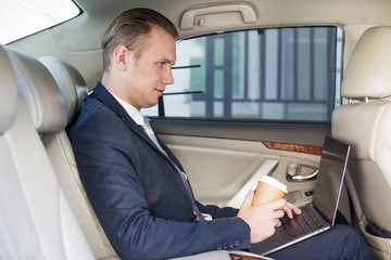 Business man using Laptop for working in car with attractive smiling, Man working concept.
