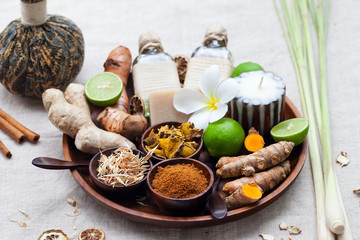 Spa, heath care set of essential oils, soap, ginger, turmeric roots and spices on a wooden tray.