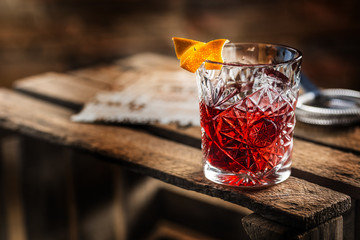 Cocktail Negroni sur une vieille planche de bois. Boire avec du gin, du campari martini rosso et de l& 39 orange